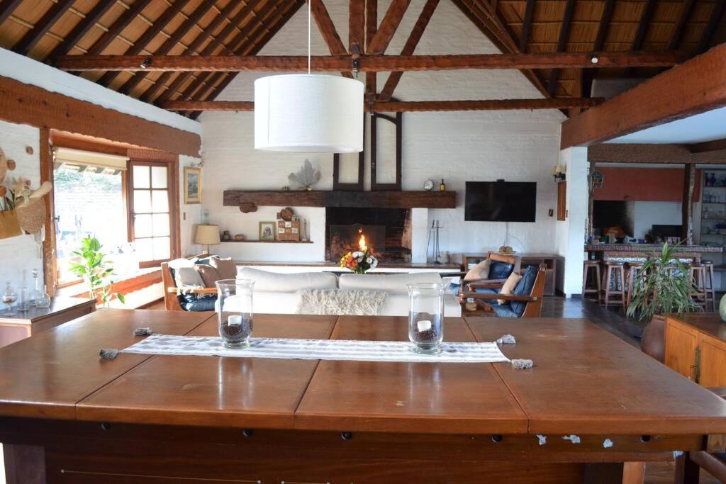 einen großen Holztisch im Wohnzimmer mit Sofa in der Unterkunft Divina casa en Carrasco con piscina in Montevideo