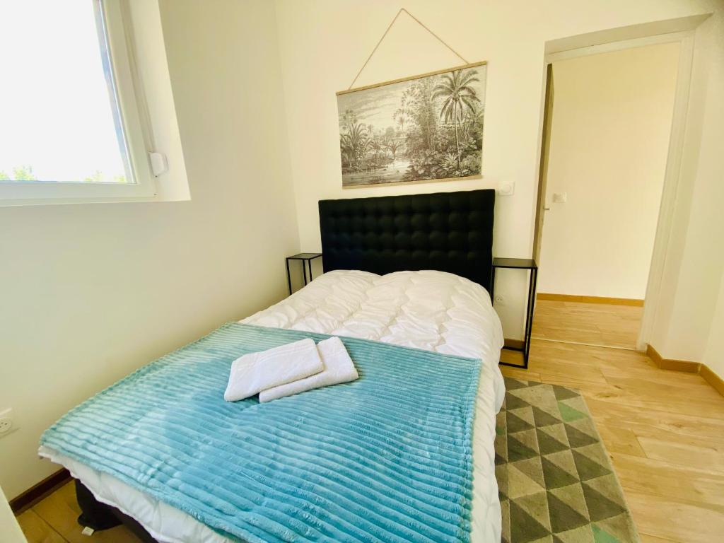a bedroom with a bed with two towels on it at Mon indépendant Wifi Parking Terrasse Un-Séjour-à-Part in Florange