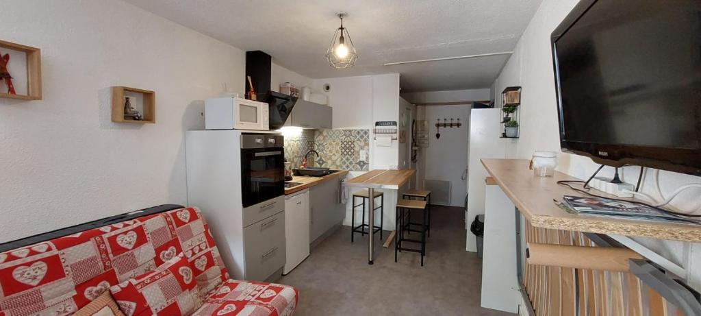 a small kitchen with a white refrigerator and a counter at Studio avec balcon face à la montagne in Cauterets