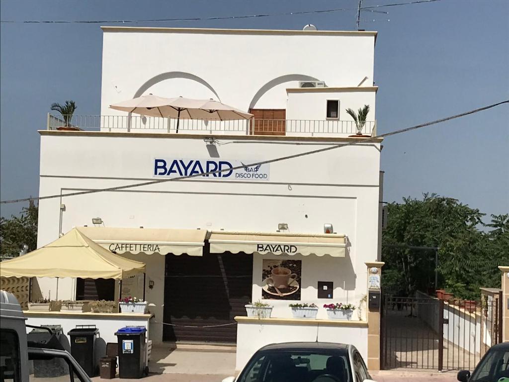 un edificio bianco con un cartello del bazar di Vacanze Fuori Porta a Grottaglie