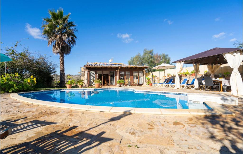 una piscina con una palmera y una casa en Pet Friendly Home In Sineu With Swimming Pool, en Sineu