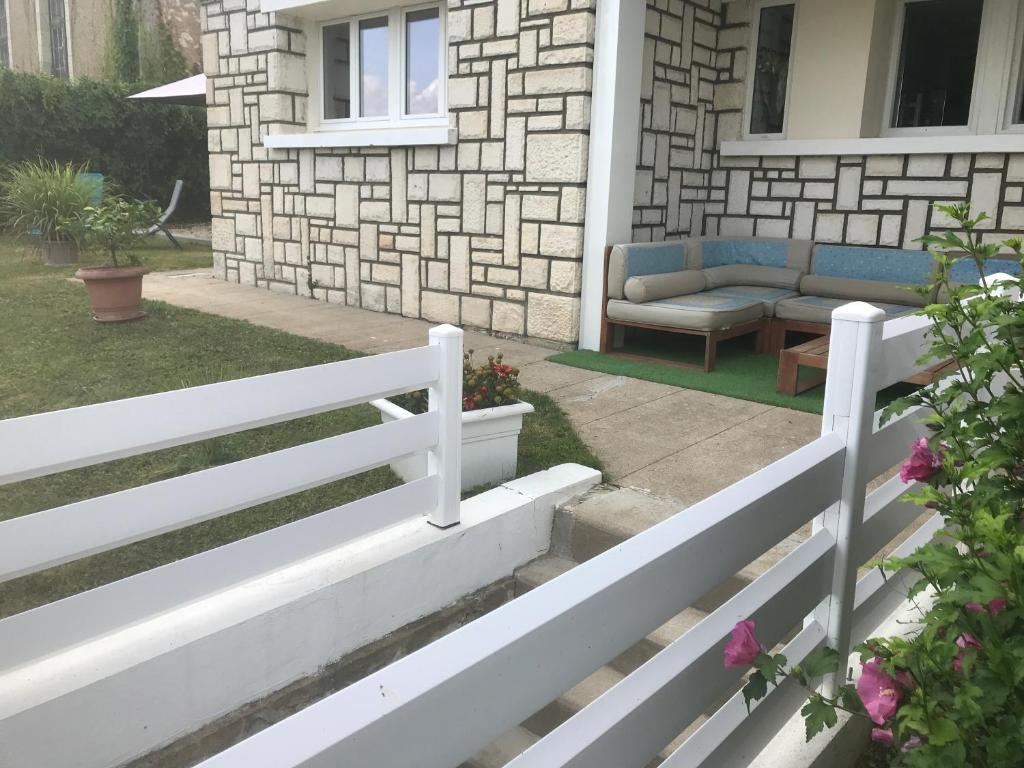einen weißen Zaun vor einem Haus in der Unterkunft Villa BAKARA in La Roche-Posay