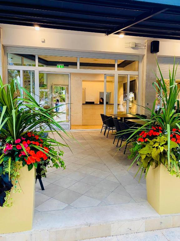 a lobby of a building with plants and flowers at Zlatni Rat Beach Resort in Bol