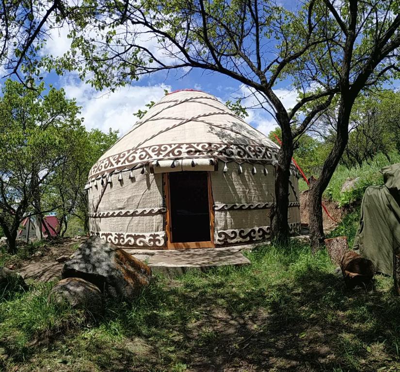 a large dome house with a door in a field at Turan Handmade Yurt with Heated Floors in Karakol