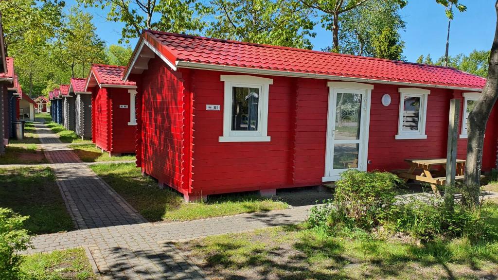 eine Reihe roter Häuser auf einer Straße in der Unterkunft Holiday Resort & Camping InterCamp'84 in Łeba