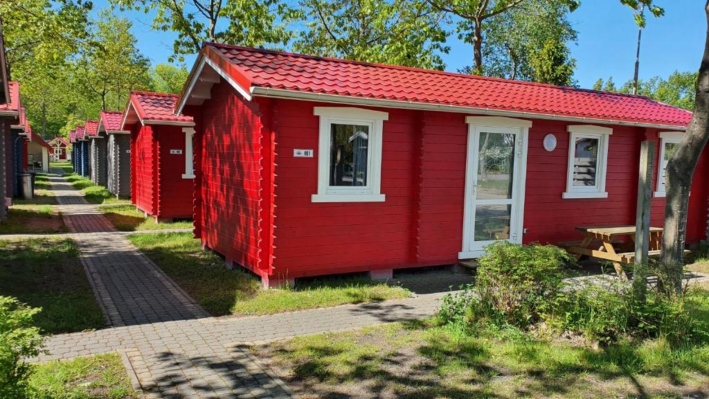 a row of red houses on a street at Holiday Resort & Camping InterCamp'84 in Łeba