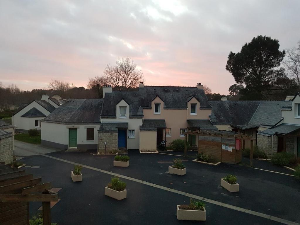 un groupe de maisons dans un parking dans l'établissement Chez Christine, à Ploemel