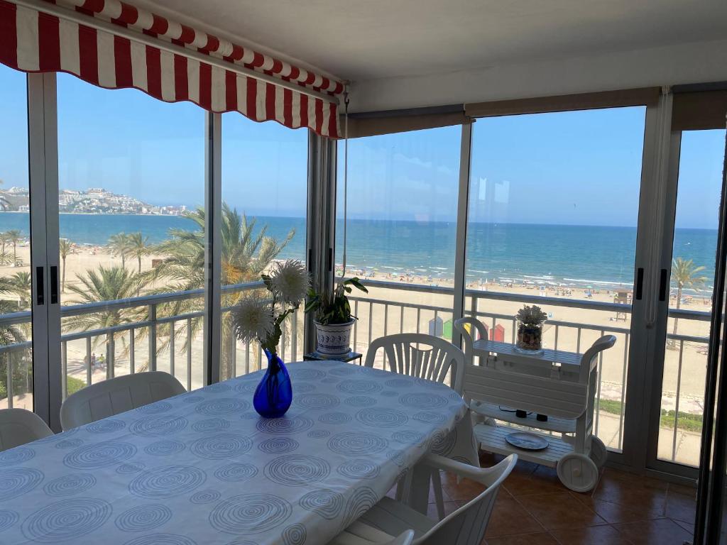 ein Esszimmer mit einem Tisch und Strandblick in der Unterkunft FRENTE AL MAR in Cullera