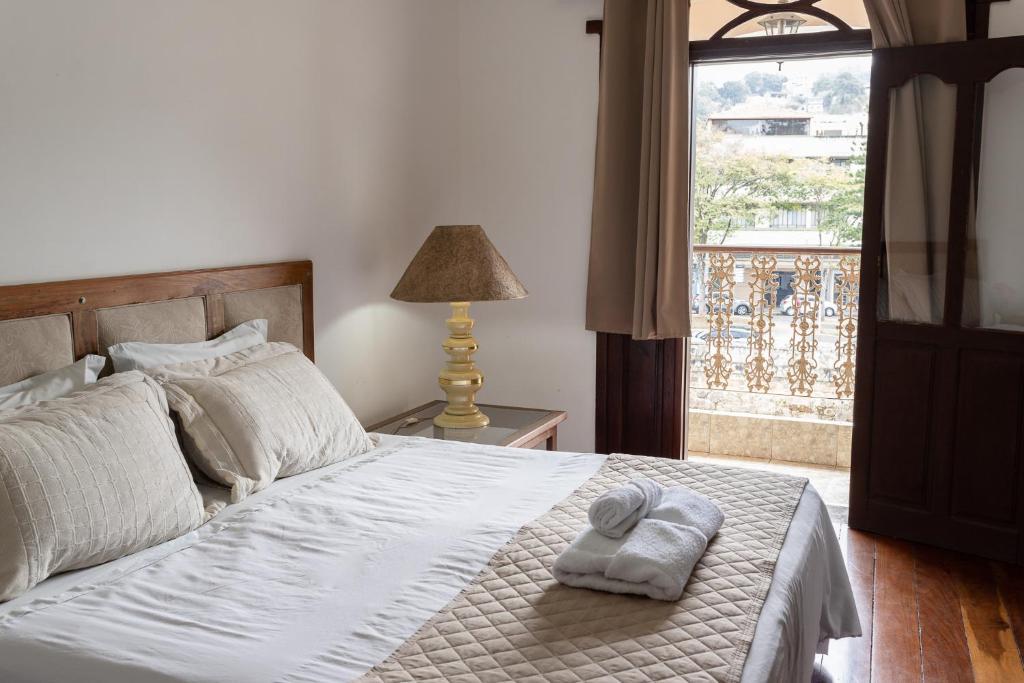 a bedroom with a bed with a towel on it at Pousada dos Sinos in São João del Rei