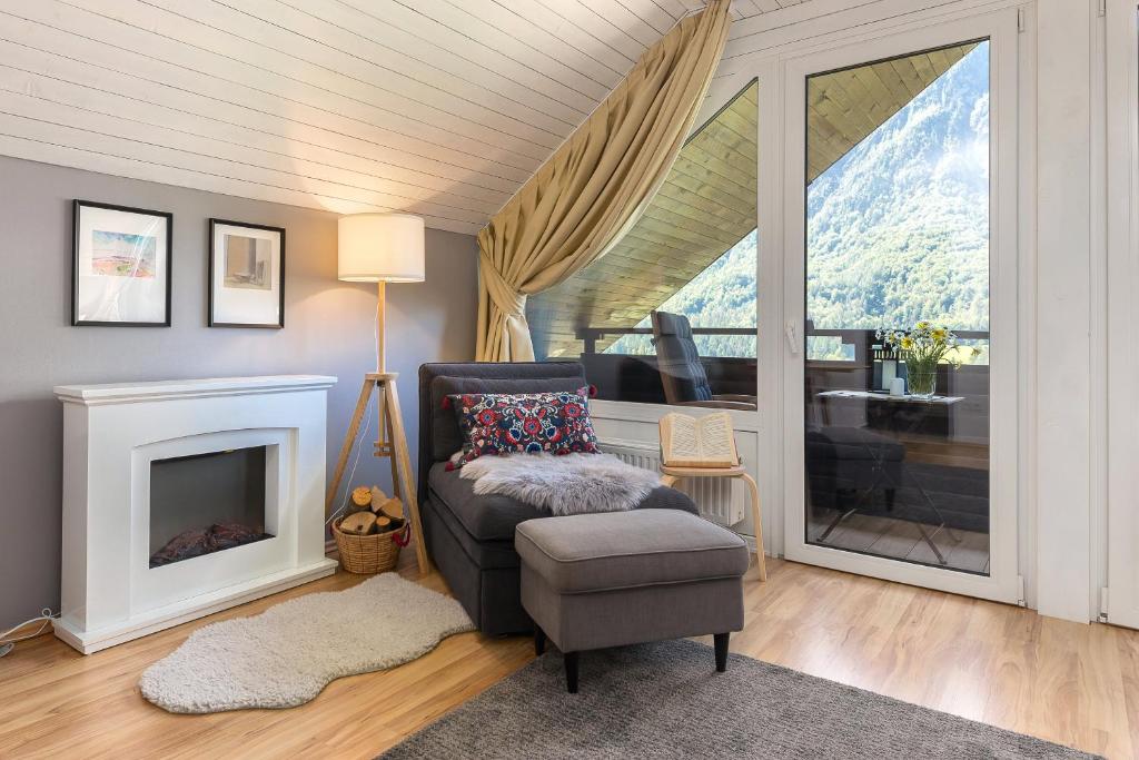 a living room with a chair and a fireplace at Rož'ca apartments with mountain view in Mojstrana