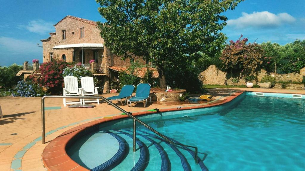 a swimming pool with two chairs and a house at La Casa di Gilda in Gizzeria