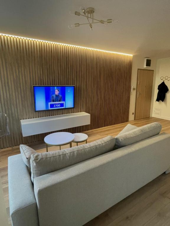 a living room with a couch and a flat screen tv at Apartament Lili Słoneczne Tarasy in Dziwnówek
