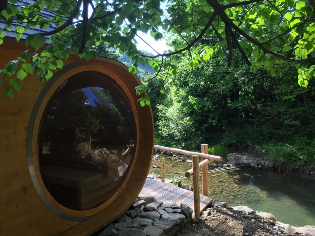 a circular mirror in front of a pool of water at Agropensjonat Tramp z góralskim spa in Żabnica
