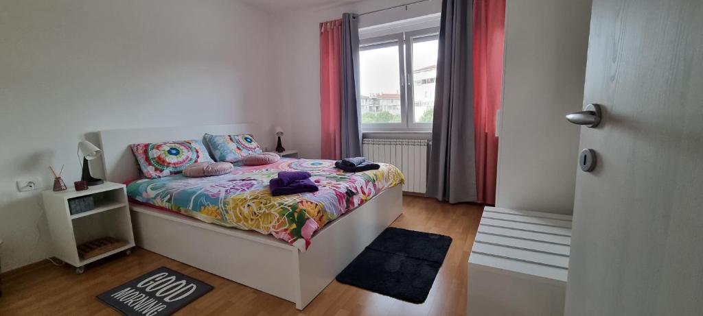 um pequeno quarto com uma cama e uma janela em Apartment Lucky 7 em Izola