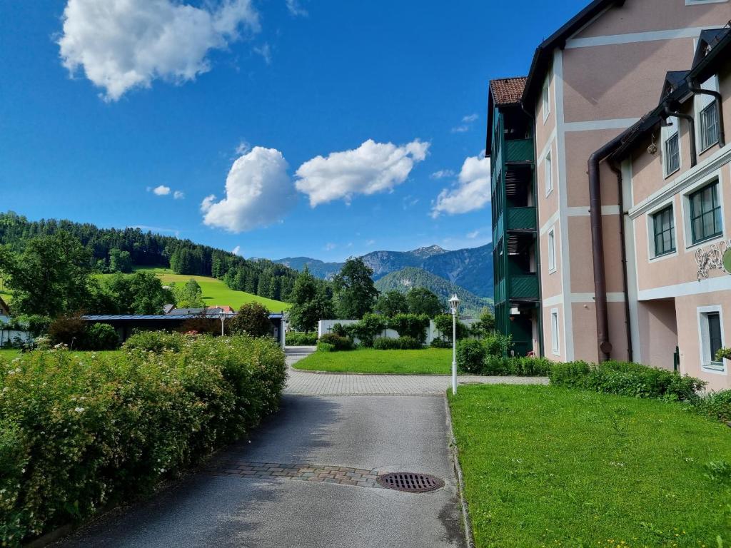 a road leading to a building with mountains in the background at Apartment Seebachhof in Edlbach