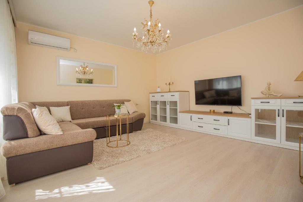 ein Wohnzimmer mit einem Sofa und einem Flachbild-TV in der Unterkunft Apartment La Casa - Sebenico in Šibenik