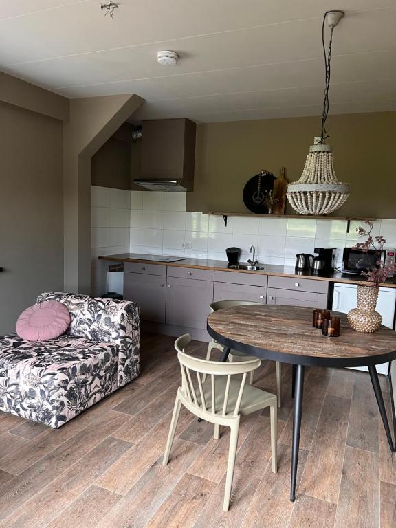 cocina y sala de estar con mesa y sofá en Parsingel, en Oostermeer