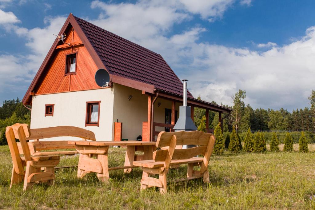 a house with a table and chairs in front of it at Tęcza Mazur in Kątno