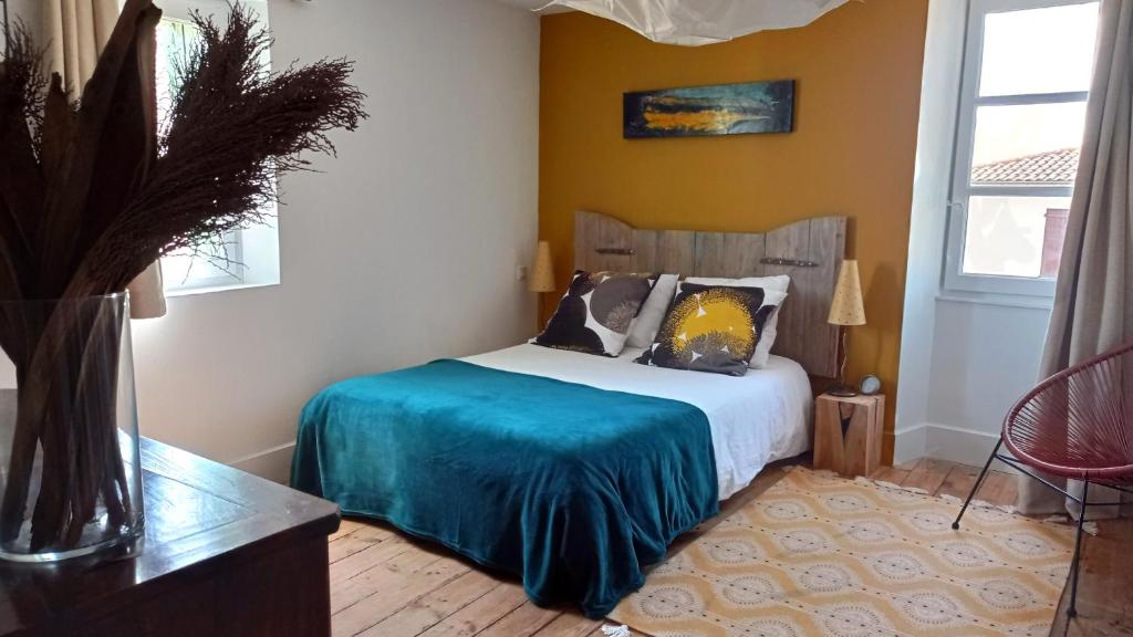 St ybars chez Annick et Alain في Saint-Ybars: غرفة نوم مع سرير وبطانية زرقاء