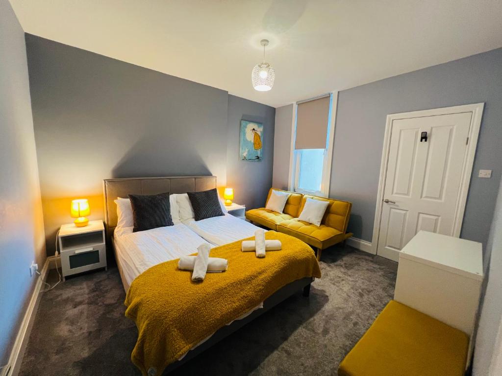 a bedroom with a large bed and a couch at Blue Belgrave in Torquay
