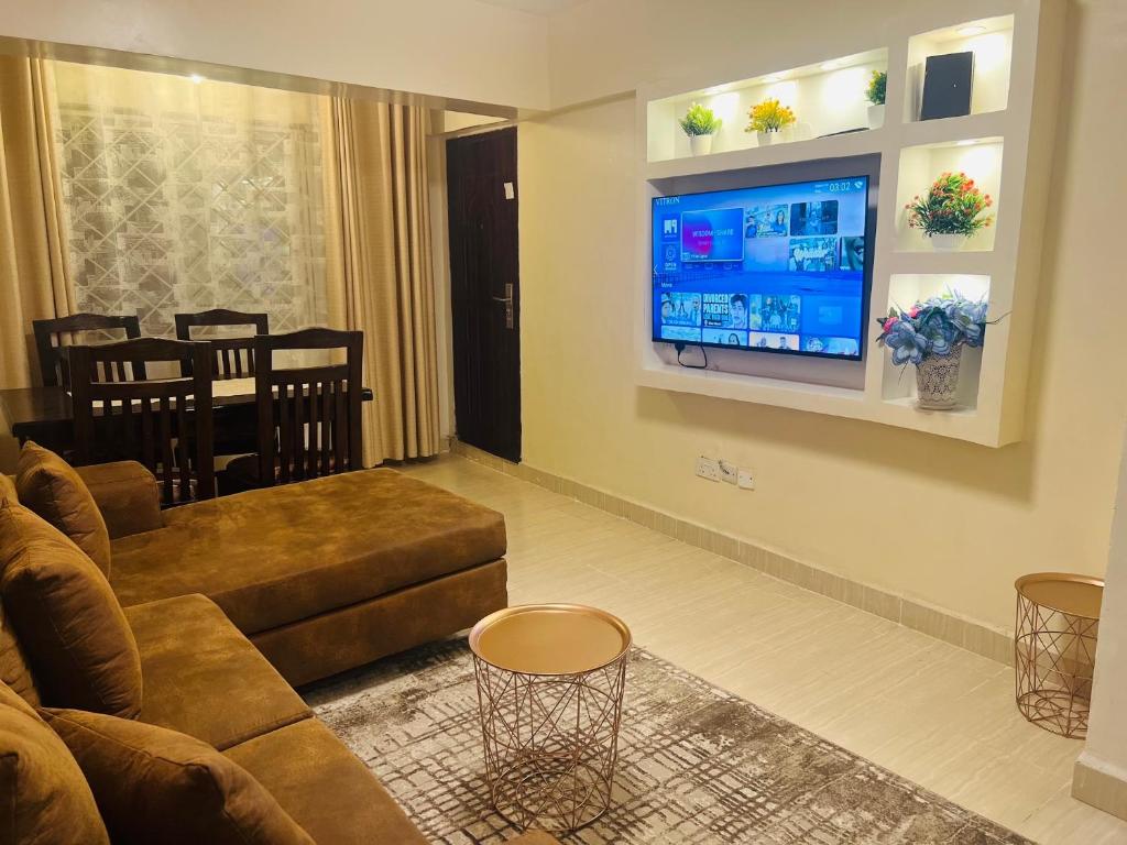 a living room with a couch and a flat screen tv at Eastleigh Executive Furnished Apartments next to BBS Mall in Nairobi