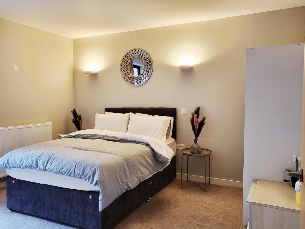 une chambre avec un lit avec un miroir au mur dans l'établissement Luxury City Apartment in JQuarter Birmingham, à Birmingham
