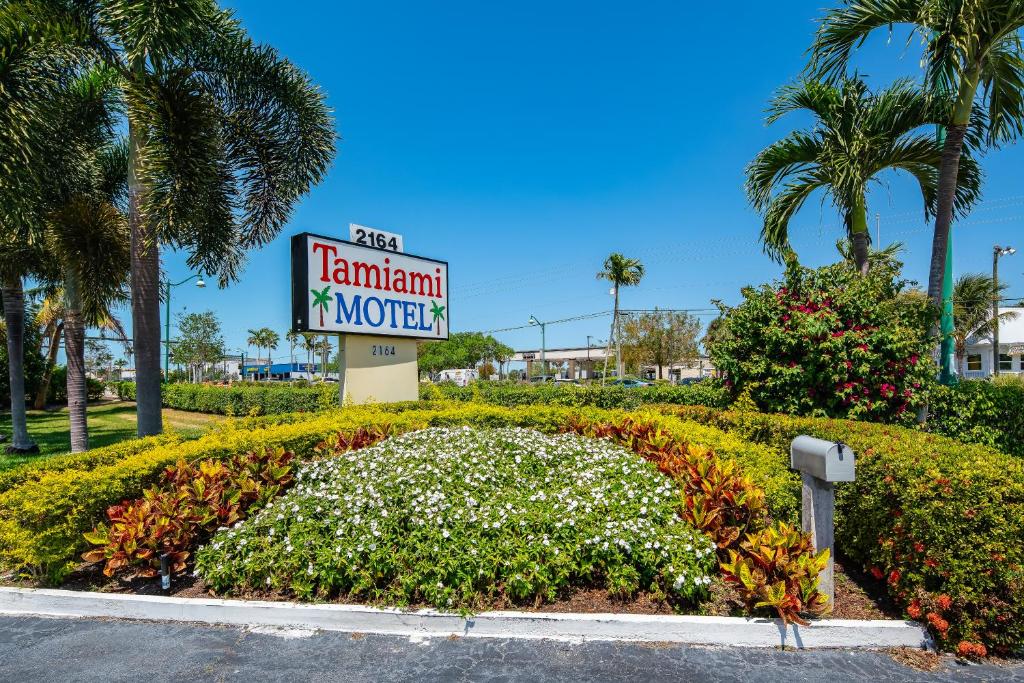 a sign for a hamiami motel with a flower garden at Tamiami Motel in Naples