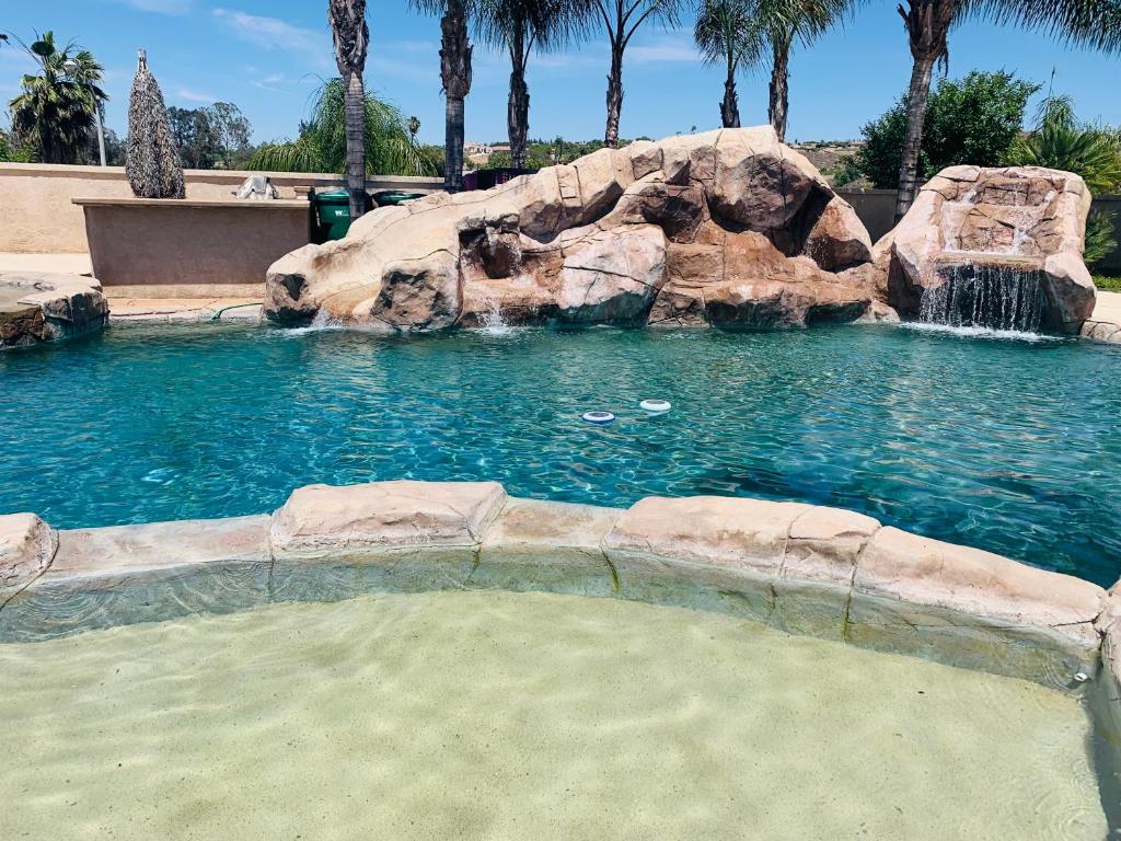 a swimming pool with a waterfall in a resort at Luxhome Rooms in Mansion in Riverside