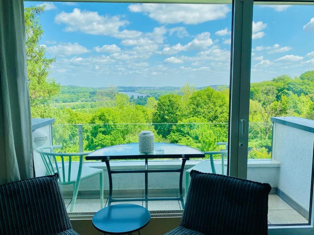 einen Tisch und Stühle auf einem Balkon mit Aussicht in der Unterkunft Blankensteiner Seeblick in Hattingen