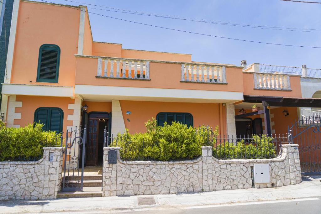 a orange house with a stone wall in front of it at Casa Vacanze Lavinia in Castro di Lecce