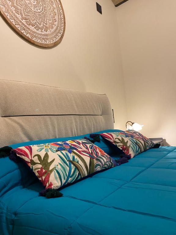 a blue bed with a pillow on top of it at B&B Terrazza Sul Borgo in Mogliano