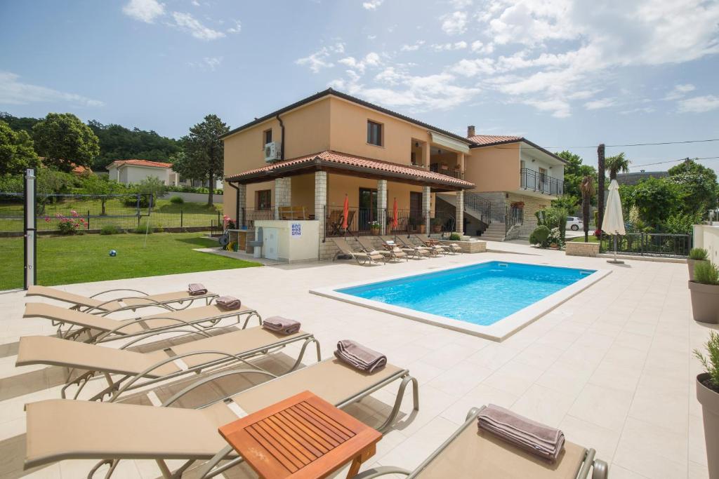 eine Villa mit einem Pool und Gartenmöbeln in der Unterkunft Villa Ivana in Labin