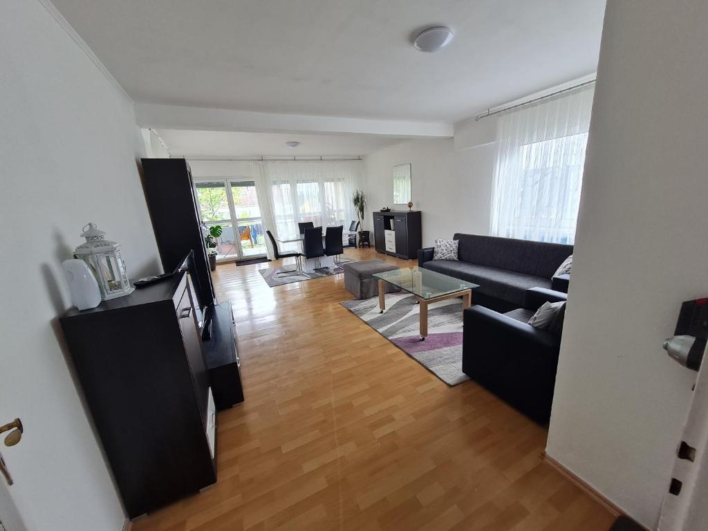 een woonkamer met een bank en een tafel bij Ferienwohnung Ramstein in Ramstein-Miesenbach