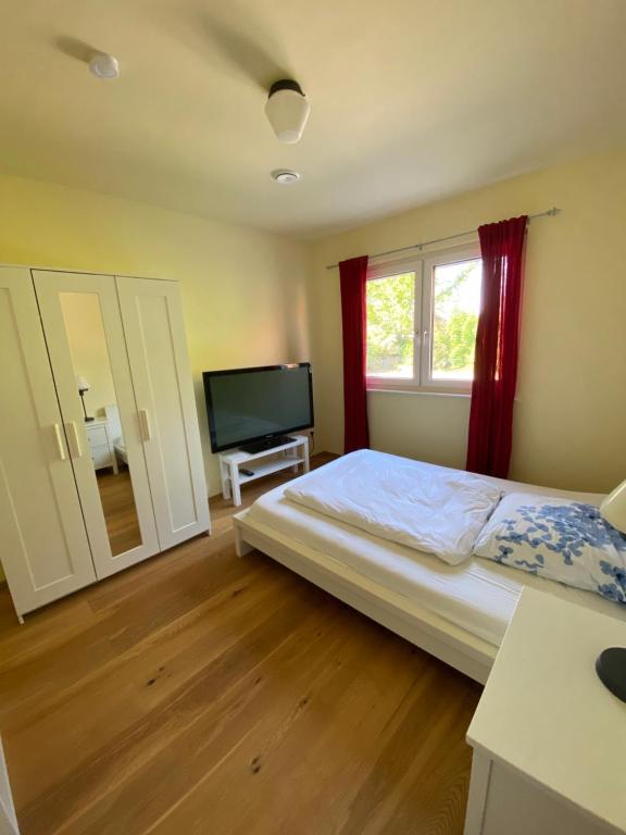 a bedroom with a bed and a flat screen tv at Schönes Privatzimmer Region Hannover in Springe