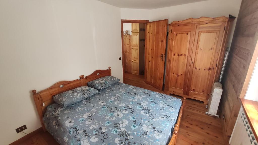 a bedroom with a bed and a wooden cabinet at Appartamento Gressoney-Saint-Jean (Obre Biel) - I Larici in Gressoney-Saint-Jean