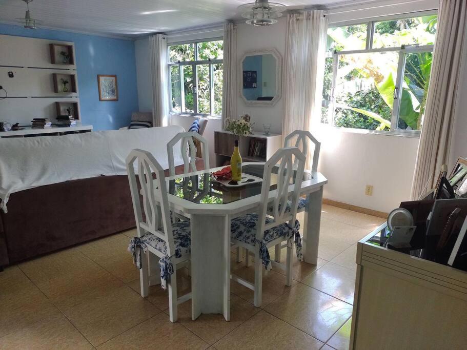 uma sala de estar com uma mesa e cadeiras e uma cama em Cantinho aconchegante em Angra dos Reis em Angra dos Reis