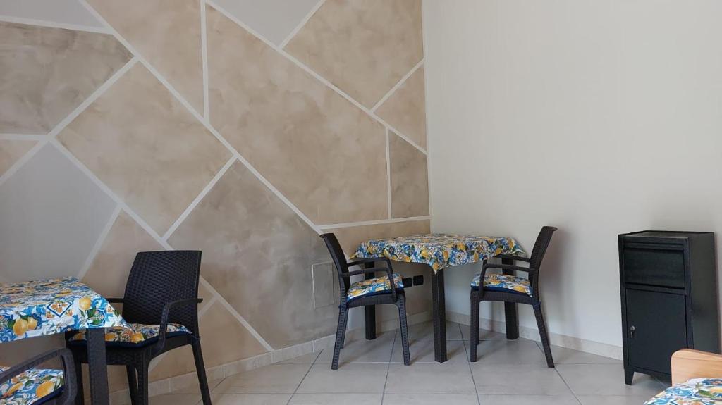 ein Zimmer mit 3 Tischen und Stühlen und einer Wand in der Unterkunft B&B L'agrumeto in Nocera Inferiore