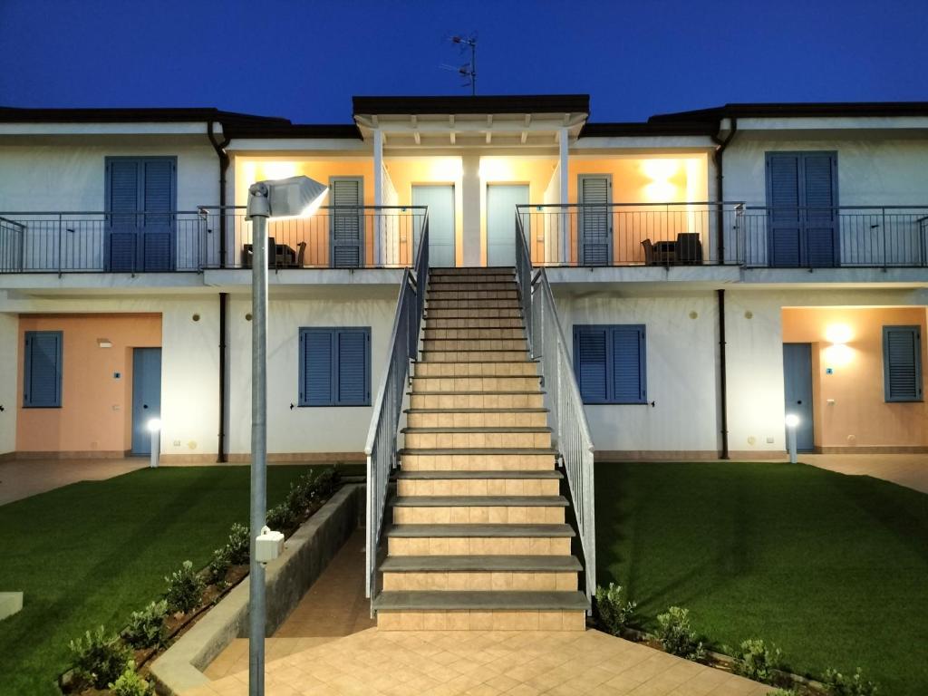 a house with stairs leading up to it at night at Icaro Residence Apartments with a beautiful pool in SantʼAgata di Militello