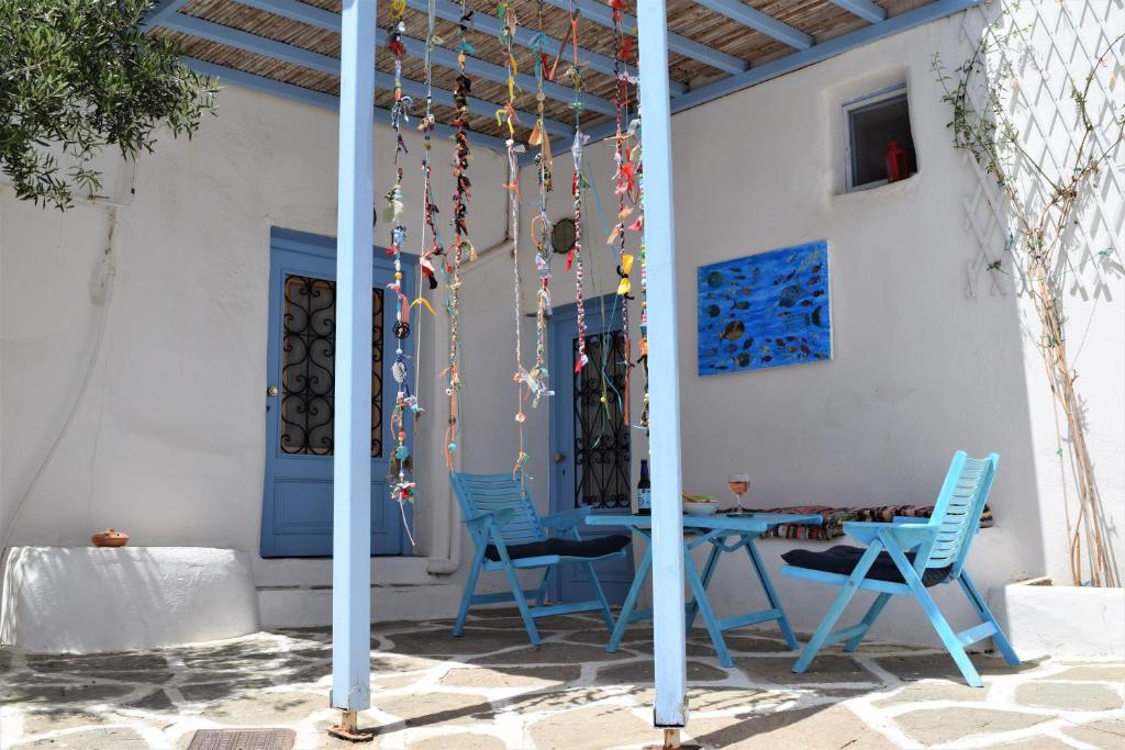 a patio with blue chairs and a table at Το κάτω σπίτι της Μαριάνθης in Márpissa