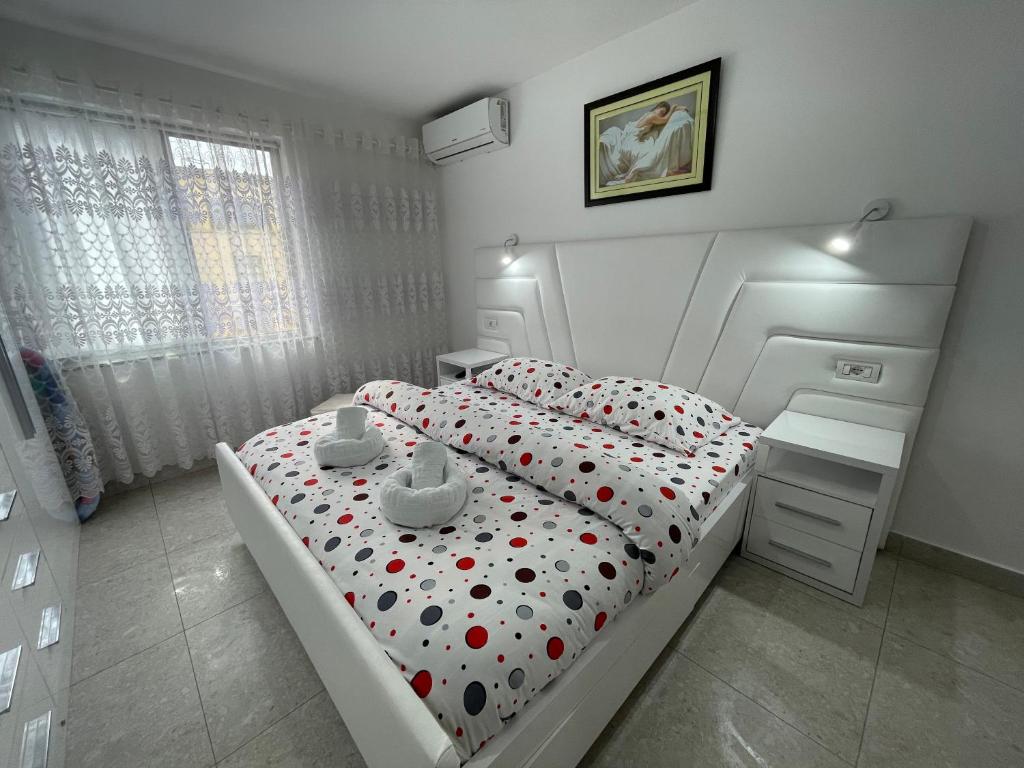 1 dormitorio con 1 cama blanca con lunares en ROMANCE Apartments, en Tirana