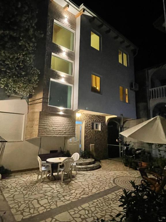a building with a table and chairs in front of it at Casa Alea in Ulcinj