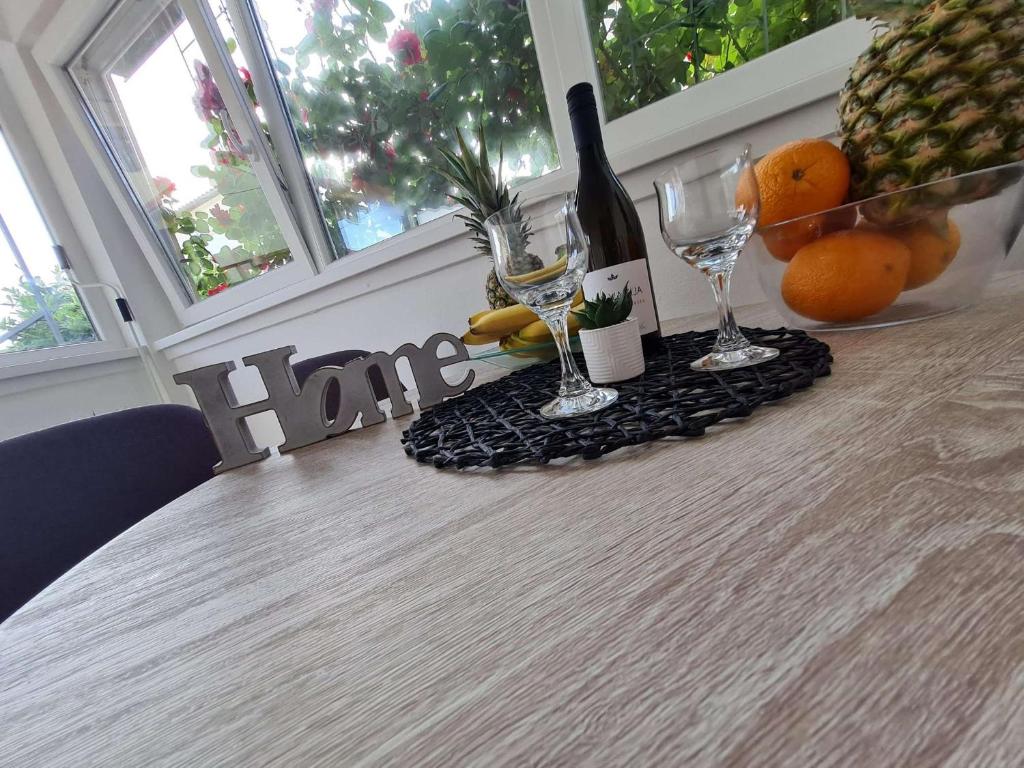una mesa con copas de vino y fruta. en Apartmani Lovre i Zara, en Zadar