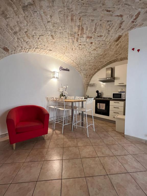 - un salon avec une table et une chaise rouge dans l'établissement casa claudia, à Putignano