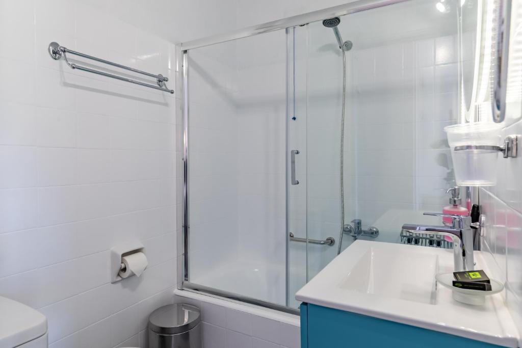 a glass shower in a bathroom with a sink at Panormos Beach Hotel Skopelos in Panormos Skopelos