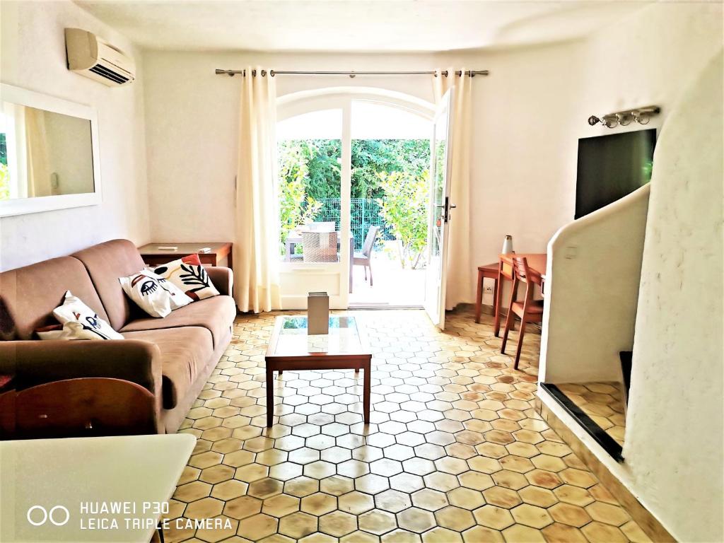 uma sala de estar com um sofá e uma mesa em Appartement 16 en duplex, deux chambres - LES SUITES DE ROBINSON - Résidence avec piscine en bord de Siagne, à Mandelieu-La-Napoule em Mandelieu-la-Napoule