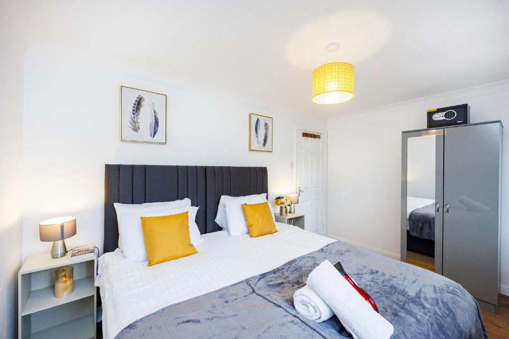 um quarto com uma cama grande com almofadas laranja e branca em Lovely 2 Bd Hse with Parking near Excel em Londres