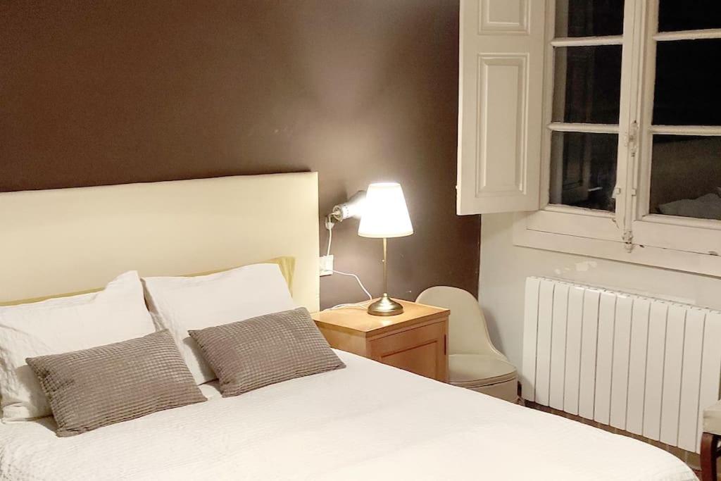 1 dormitorio con cama blanca y mesa con lámpara en Acogedor apartamento en el Casco Antiguo en Vigo