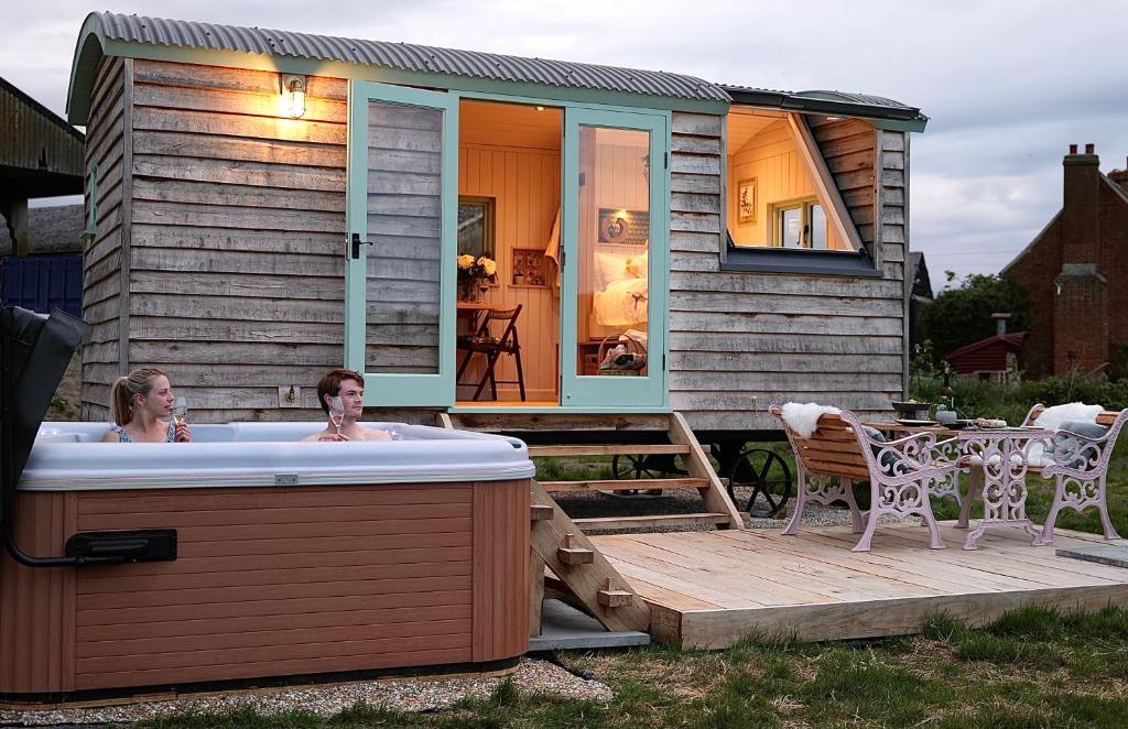 two women in a hot tub on a deck with a house at Luxury Retreat 30mins Taxi Ride From West London in Chessington