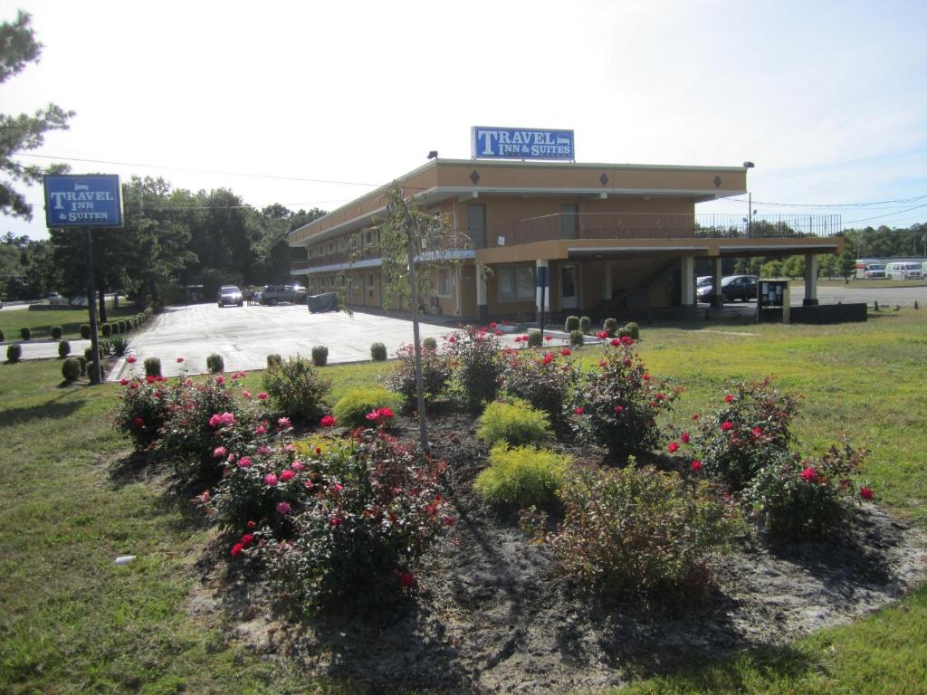 a building with a bunch of flowers in front of it at Travel Inn and Suites in Lakehurst