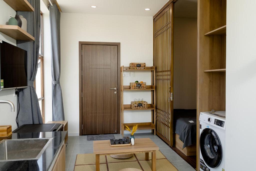 una pequeña cocina con una puerta de madera y una mesa en Natsu No Hanabi Villa & Apartment, en Da Nang